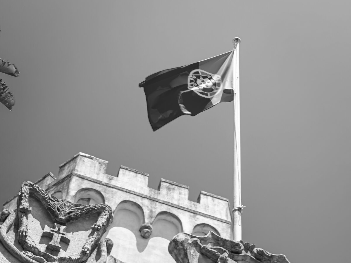Portuguese flag flying over a historic castle — symbol of the article 91-B residency framework